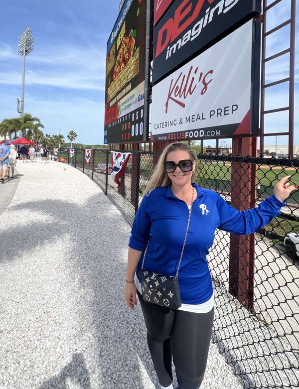 Threshers Stadium Kelli's Sign with Kelli to the side of the sign